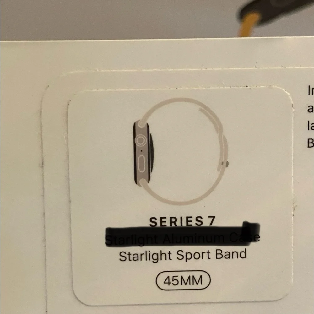 New Apple 7 Smartwatch Band in Starlight with charging cord.